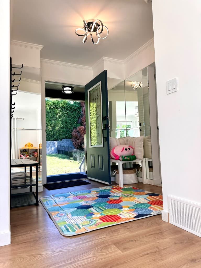 Front entrance with a colorful play mat and the door open to the yard